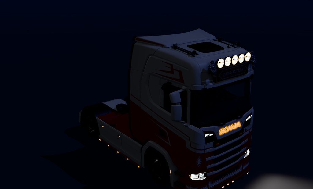 The same Scania at night with its lights on